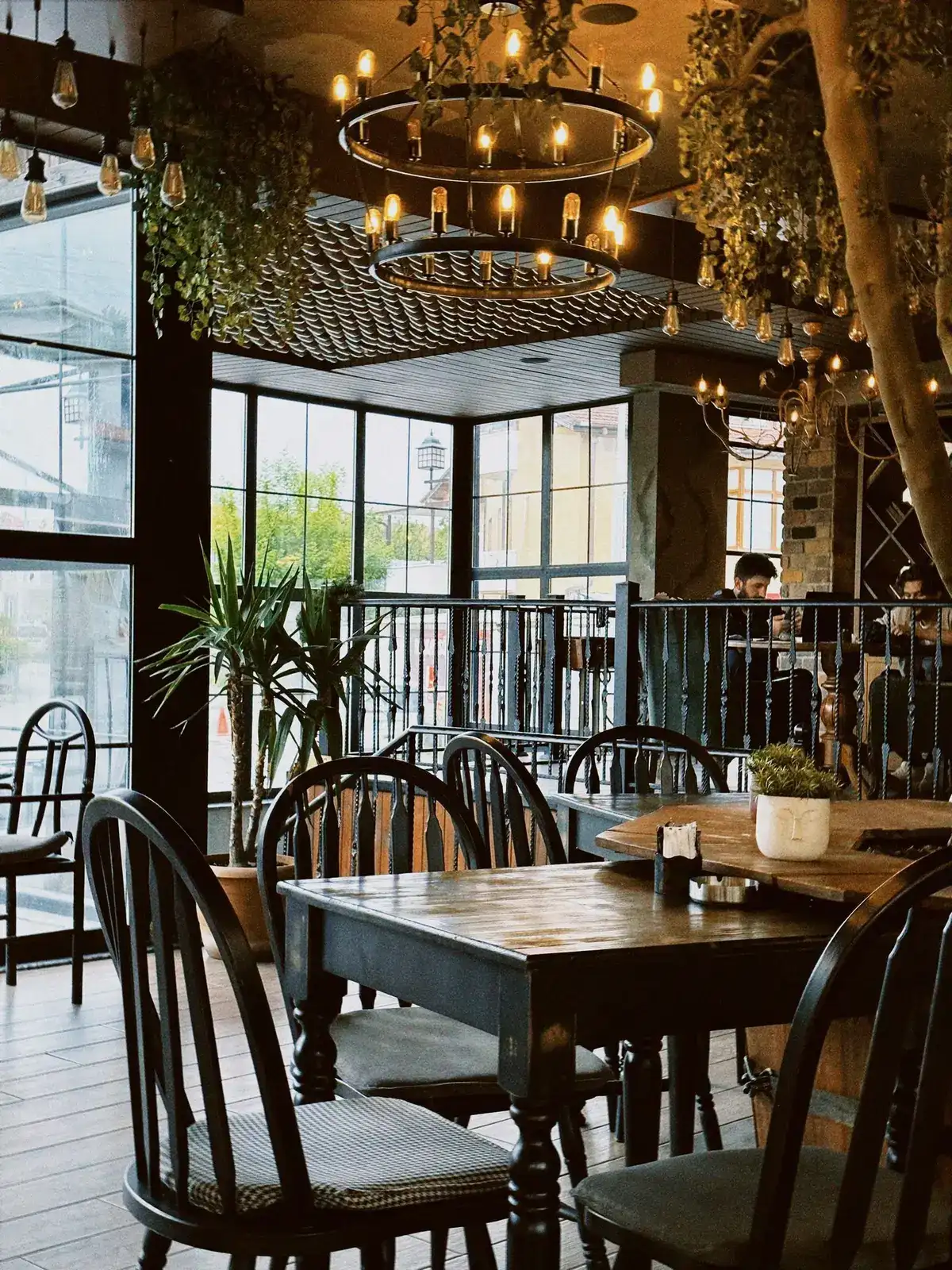 Restaurant med træborde, stole og varme lamper